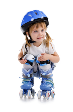 A picture of a small child in roller skates wearing a lot of safety and protective gear to skate in