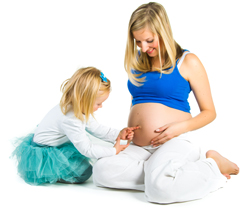 A picture of a pregnant mom sitting with her daughter