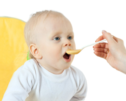 A picture of a Toddler being fed soft food